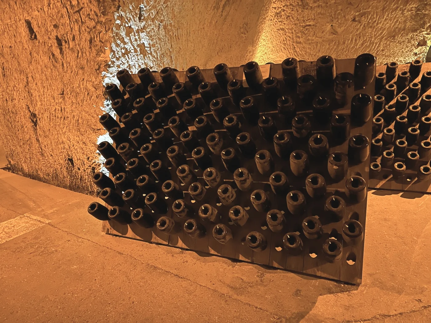 Champagne bottles on riddling racks in a Reims chalk cellar